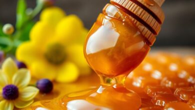 عسل ذهبي مع زهور وشمع العسل.